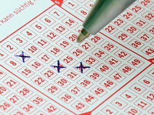 Pen is used to cross out numbers on a lottery card, thus selecting Lotto Numbers